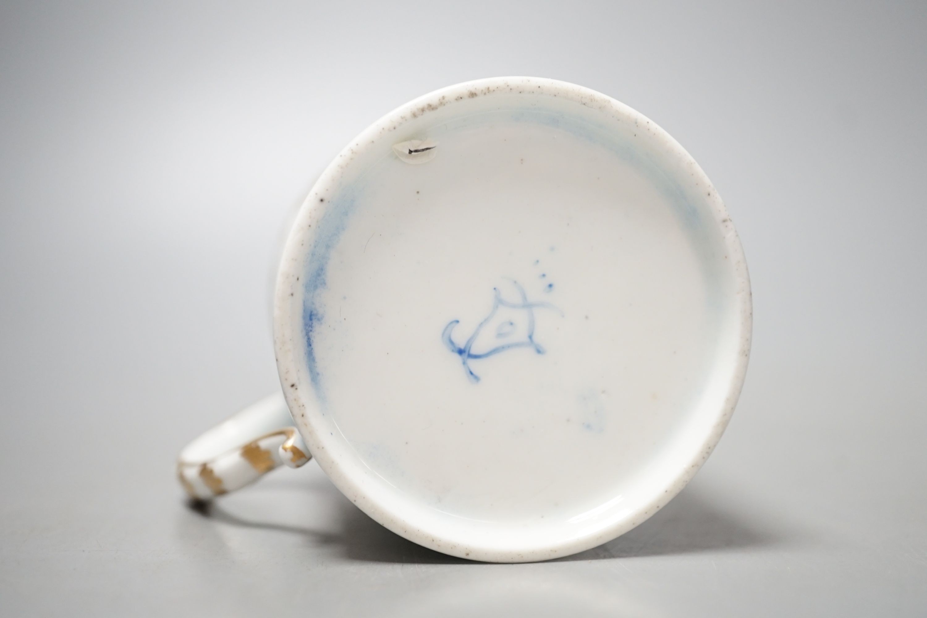 A Sevres coffee can painted with two birds in a tree, and other birds in flight under a richly gilded blue ground date code for 1766